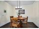 Dining room featuring dark floors and light-colored walls, complemented by natural-wood table and chairs at 3520 Woodmont Dr, Parrish, FL 34219