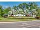 Landscaped entrance to the Silverleaf Neal Communities with trees, bushes and a sign with the community name at 3520 Woodmont Dr, Parrish, FL 34219