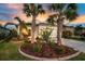 Inviting home featuring a well-manicured lawn, mature palm trees, and vibrant landscaping at 3520 Woodmont Dr, Parrish, FL 34219