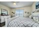Cozy bedroom with light walls, a ceiling fan, a comfortable bed, and a picturesque window view at 3520 Woodmont Dr, Parrish, FL 34219