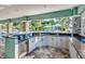 An outdoor kitchen with cabinets, granite countertops, a stainless steel refrigerator, and views of the pool at 3520 Woodmont Dr, Parrish, FL 34219
