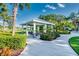A covered picnic area with seating surrounded by green space and tropical landscaping at 3520 Woodmont Dr, Parrish, FL 34219