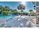 A luxurious pool area with a sparkling pool, palm trees, sunshades, and comfortable lounge chairs at 3520 Woodmont Dr, Parrish, FL 34219