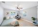 This bedroom features two windows, a ceiling fan, a bed, a desk and chair, a rug, and a plant at 3828 20Th N St, St Petersburg, FL 33714