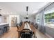 Dining room with a long wood table, modern light fixture, and adjoining kitchen at 3828 20Th N St, St Petersburg, FL 33714