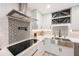 Close-up of the kitchen showcasing a stainless steel sink, sleek cooktop, and stylish subway tile backsplash at 3828 20Th N St, St Petersburg, FL 33714