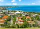 Overhead shot of orange-roofed houses amidst lush trees, with stunning views of blue ocean at 4001 5Th Ave, Holmes Beach, FL 34217