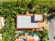 Aerial view of a home with an orange-tiled roof and two pools surrounded by tropical landscaping at 4001 5Th Ave, Holmes Beach, FL 34217