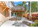 This backyard features outdoor seating with a Tiki bar, lounge chairs and meticulous landscaping at 4001 5Th Ave, Holmes Beach, FL 34217