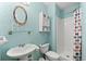 Cozy bathroom with a bright blue accent wall, pedestal sink, and shower with a patterned curtain at 4001 5Th Ave, Holmes Beach, FL 34217