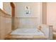 Large bathtub inside of a tiled bathroom, featuring gold hardware at 4001 5Th Ave, Holmes Beach, FL 34217