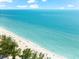 Scenic beach view with clear turquoise water, white sand, and beachgoers enjoying the sun at 4001 5Th Ave, Holmes Beach, FL 34217
