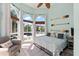 Beach-themed bedroom with whitewashed floors, chair, and three large windows at 4001 5Th Ave, Holmes Beach, FL 34217