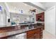 Open-concept design featuring a breakfast bar with granite countertops, dark wood cabinets, and stainless steel appliances at 4001 5Th Ave, Holmes Beach, FL 34217