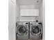 Convenient laundry area with front-load washer and dryer set and overhead storage cabinets at 4001 5Th Ave, Holmes Beach, FL 34217