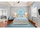 Bright main bedroom features coastal decor, tray ceilings, a ceiling fan and hardwood flooring at 4001 5Th Ave, Holmes Beach, FL 34217