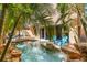 The custom pool and outdoor area boasts a waterfall, lush landscaping, and a tiki hut at 4001 5Th Ave, Holmes Beach, FL 34217