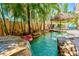 Private pool with rock waterfall and lush tropical landscaping for a secluded backyard retreat at 4001 5Th Ave, Holmes Beach, FL 34217
