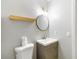 Minimalist bathroom features a round mirror, wooden shelf and a modern vanity at 4221 3Rd W Ave, Palmetto, FL 34221