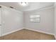 A simple bedroom with beige carpet, white trim, and a window with blinds at 4221 3Rd W Ave, Palmetto, FL 34221