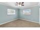 Cozy bedroom with a ceiling fan, two windows, and neutral carpet at 4221 3Rd W Ave, Palmetto, FL 34221