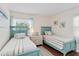 Bright bedroom featuring two twin beds with turquoise accents and a large window at 424 62Nd St, Holmes Beach, FL 34217