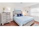 Bright bedroom featuring a bed with blue accents, wood floors, and a large window at 424 62Nd St, Holmes Beach, FL 34217