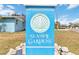 Seaside Gardens community sign with blue paint, sea shell logo, and manicured landscaping at 424 62Nd St, Holmes Beach, FL 34217