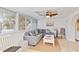Enclosed sunroom with tile floor and view of yard has cozy gray sofa and fan at 424 62Nd St, Holmes Beach, FL 34217