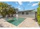 Beautiful in-ground pool and jacuzzi are surrounded by palm trees and patio with lounge chairs at 424 62Nd St, Holmes Beach, FL 34217