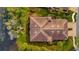 Aerial view of a house near a lake with a private yard surrounded by trees and landscaping at 4344 Nizza Ct, Venice, FL 34293
