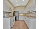 Well-equipped kitchen featuring white cabinets, stainless steel appliances, and tile floors for easy maintenance at 4344 Nizza Ct, Venice, FL 34293