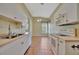 Traditional kitchen features white cabinetry, appliances, tile flooring and a window with custom curtains at 4344 Nizza Ct, Venice, FL 34293