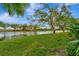 Scenic view of the water with trees and lush green grass in a well-maintained community at 4344 Nizza Ct, Venice, FL 34293