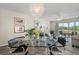 Elegant dining area adjacent to living room with glass table and stylish chandelier, overlooking the golf course at 4440 Fairways Blvd # 210, Bradenton, FL 34209