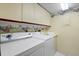 Functional laundry room with washer, dryer, and overhead storage at 4440 Fairways Blvd # 210, Bradenton, FL 34209