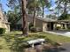 Exterior view of home with covered parking, mature trees and landscaping at 4944 Village Gardens Dr # 151, Sarasota, FL 34234