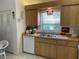 Bright kitchen featuring wood cabinets, white appliances, breakfast nook, and plenty of storage at 4944 Village Gardens Dr # 151, Sarasota, FL 34234