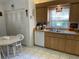 Bright kitchen featuring wood cabinets, white appliances, breakfast nook, and plenty of storage at 4944 Village Gardens Dr # 151, Sarasota, FL 34234