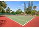 Community tennis court with net, fencing and shade trees, offering a great recreational space at 4944 Village Gardens Dr # 151, Sarasota, FL 34234