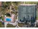 Aerial view of tennis court, lawn chairs, and a sparkling community pool with lush greenery at 5055 Gulf Of Mexico Dr # 422, Longboat Key, FL 34228