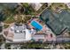 Aerial view of the pool area featuring lounge chairs, umbrellas, a spa, and tennis courts at 5055 Gulf Of Mexico Dr # 422, Longboat Key, FL 34228