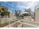 Exterior shot of balconies, tennis courts and brick walkways under a sunny blue sky at 5055 Gulf Of Mexico Dr # 422, Longboat Key, FL 34228