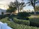 Landscaped garden with lush foliage, palm trees, and nearby tennis courts at 5055 Gulf Of Mexico Dr # 422, Longboat Key, FL 34228
