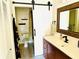Stylish bathroom with wood vanity, white countertop, barn door, and decorative mirror at 5061 Barrington Cir # 1302, Sarasota, FL 34234