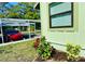 Exterior view of a house with a carport and a red car parked nearby with beautiful front plants at 5061 Barrington Cir # 1302, Sarasota, FL 34234