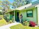 Charming one-story green house with inviting front porch, garden, and manicured lawn at 5061 Barrington Cir # 1302, Sarasota, FL 34234