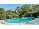 Inviting swimming pool surrounded by green landscape and mature trees, offering a serene and private outdoor retreat at 5061 Barrington Cir # 1302, Sarasota, FL 34234