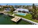 Aerial view of a waterfront home with a private dock, pool, and lush landscaping at 527 Key Royale Dr, Holmes Beach, FL 34217
