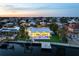 Stunning waterfront home with a private pool, dock, and beautifully landscaped yard at sunset at 527 Key Royale Dr, Holmes Beach, FL 34217